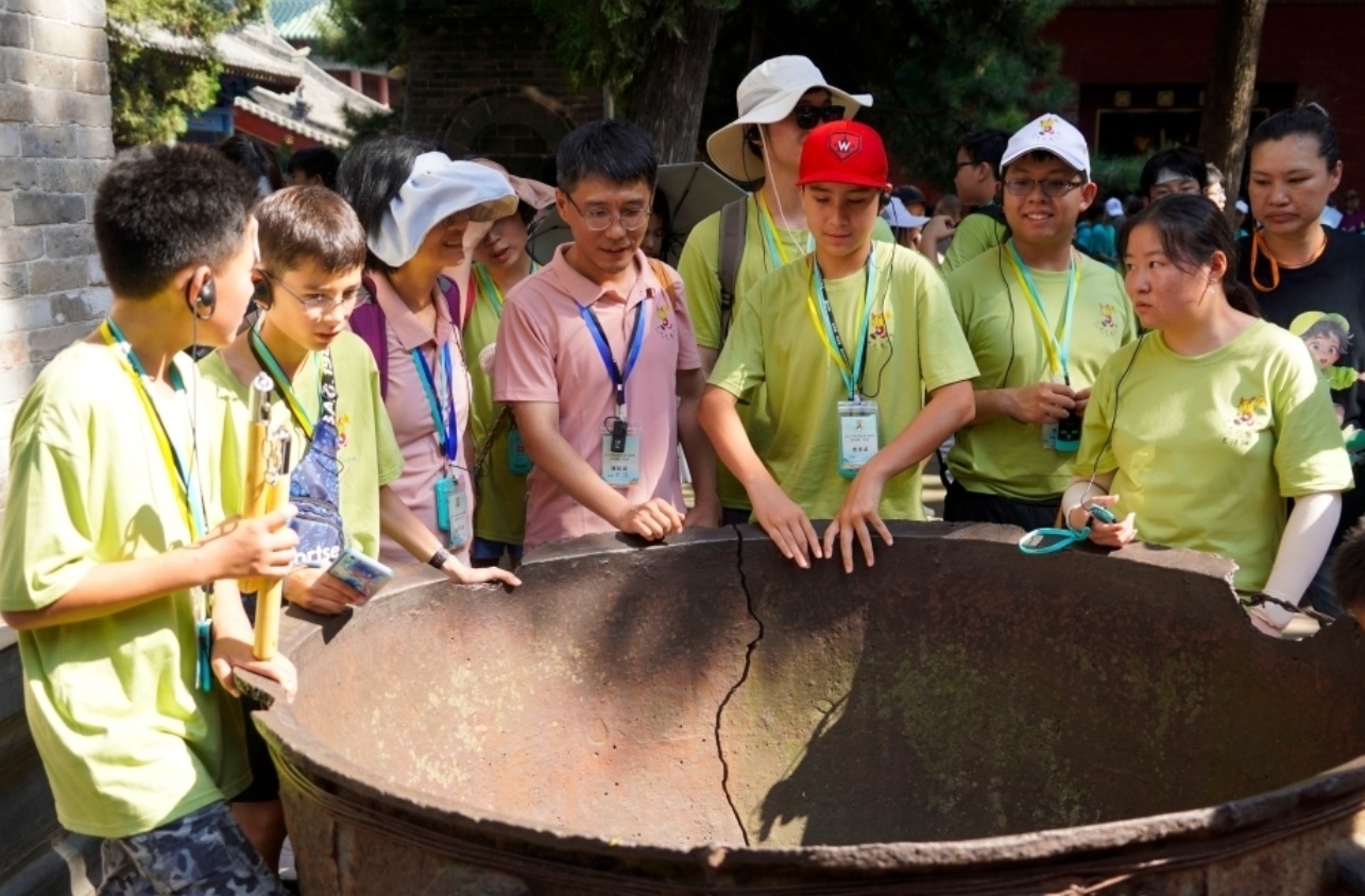 海外华裔青少年聆听少林寺明代大铁锅由来 范晓恒 摄