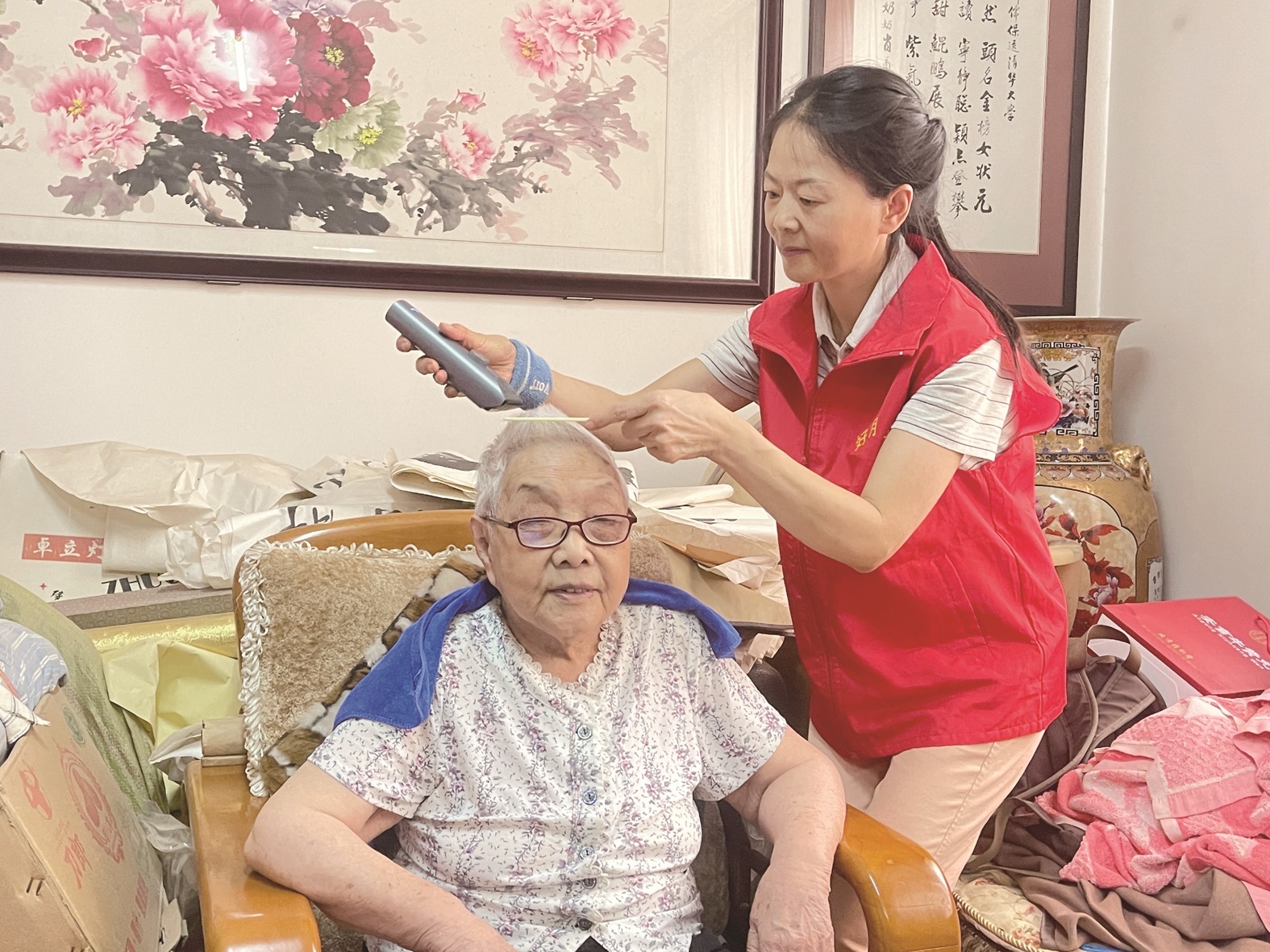 志愿者李智霞给肖菊秋老人理发 王若馨 摄